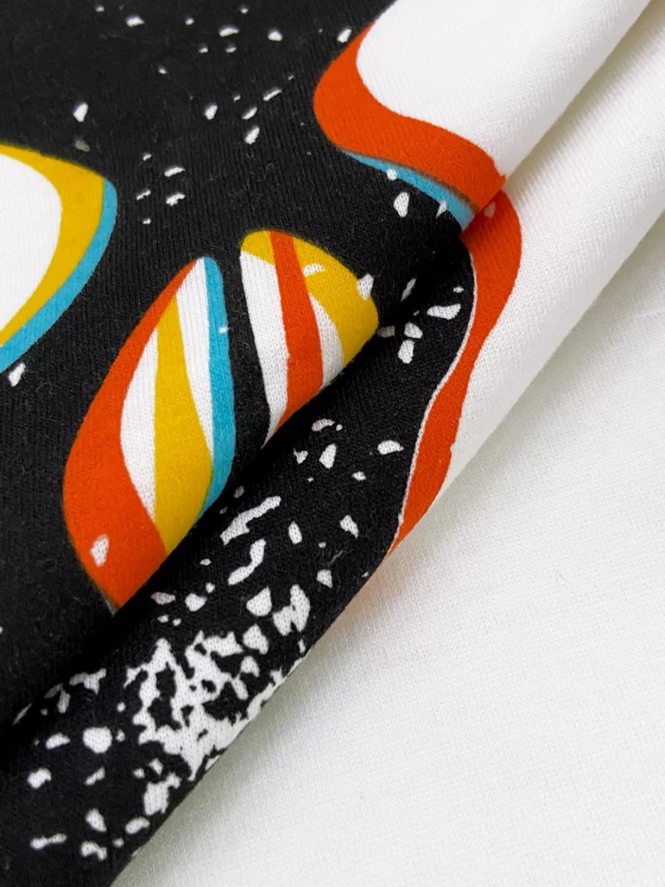 A close-up of a black t-shirt with a colorful abstract graphic print.