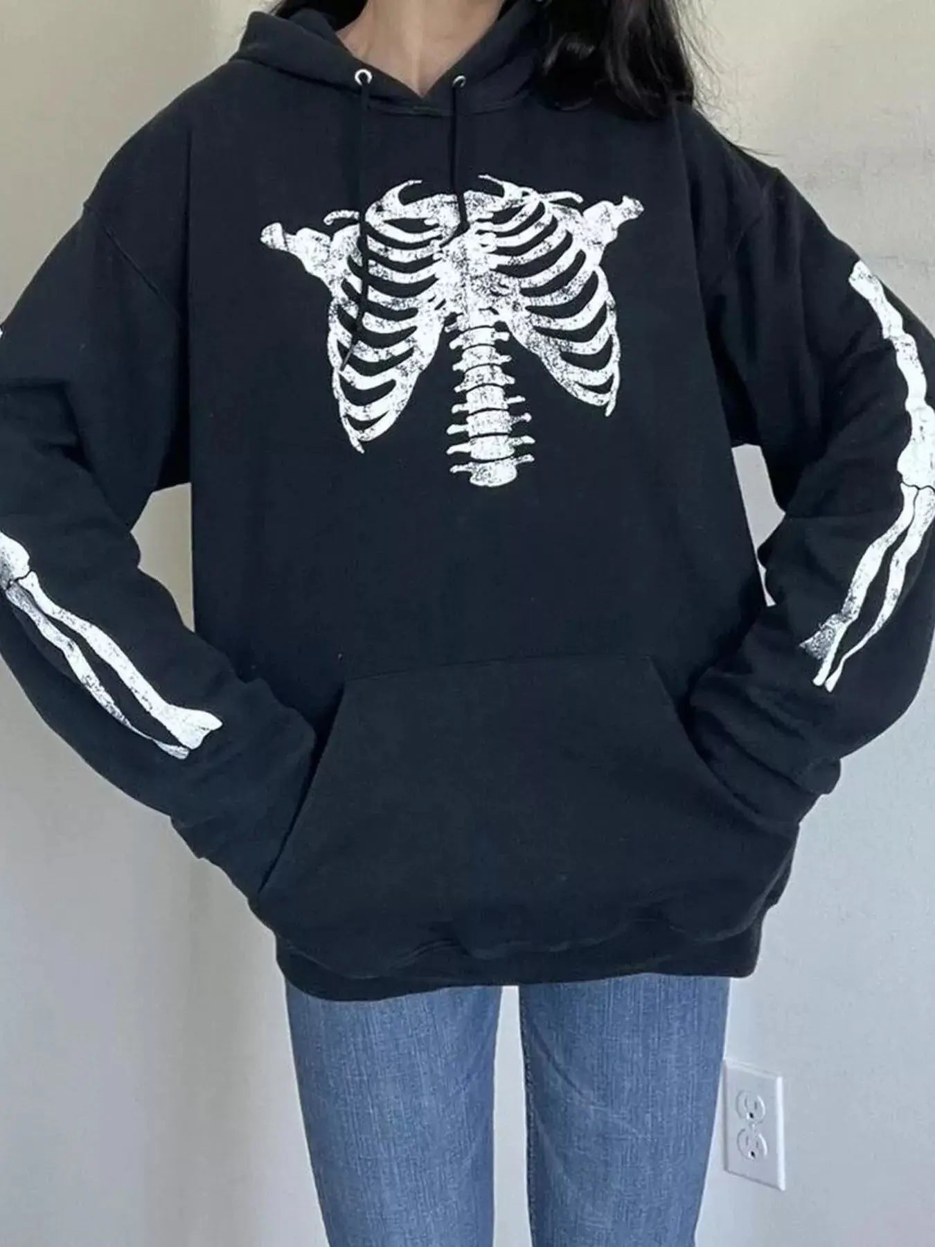 Black long sleeve hoodie with a white skeleton graphic and front pocket.