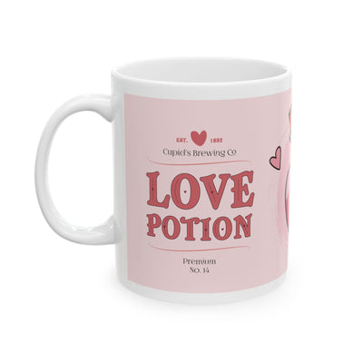 White ceramic mug with a pink heart-shaped potion bottle design, surrounded by small hearts, ideal for romantic gifting.