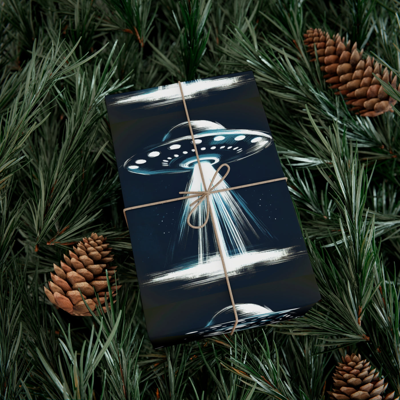 Wrapping paper with a dark blue background featuring a UFO with a beam of light, surrounded by pine needles and pinecones.