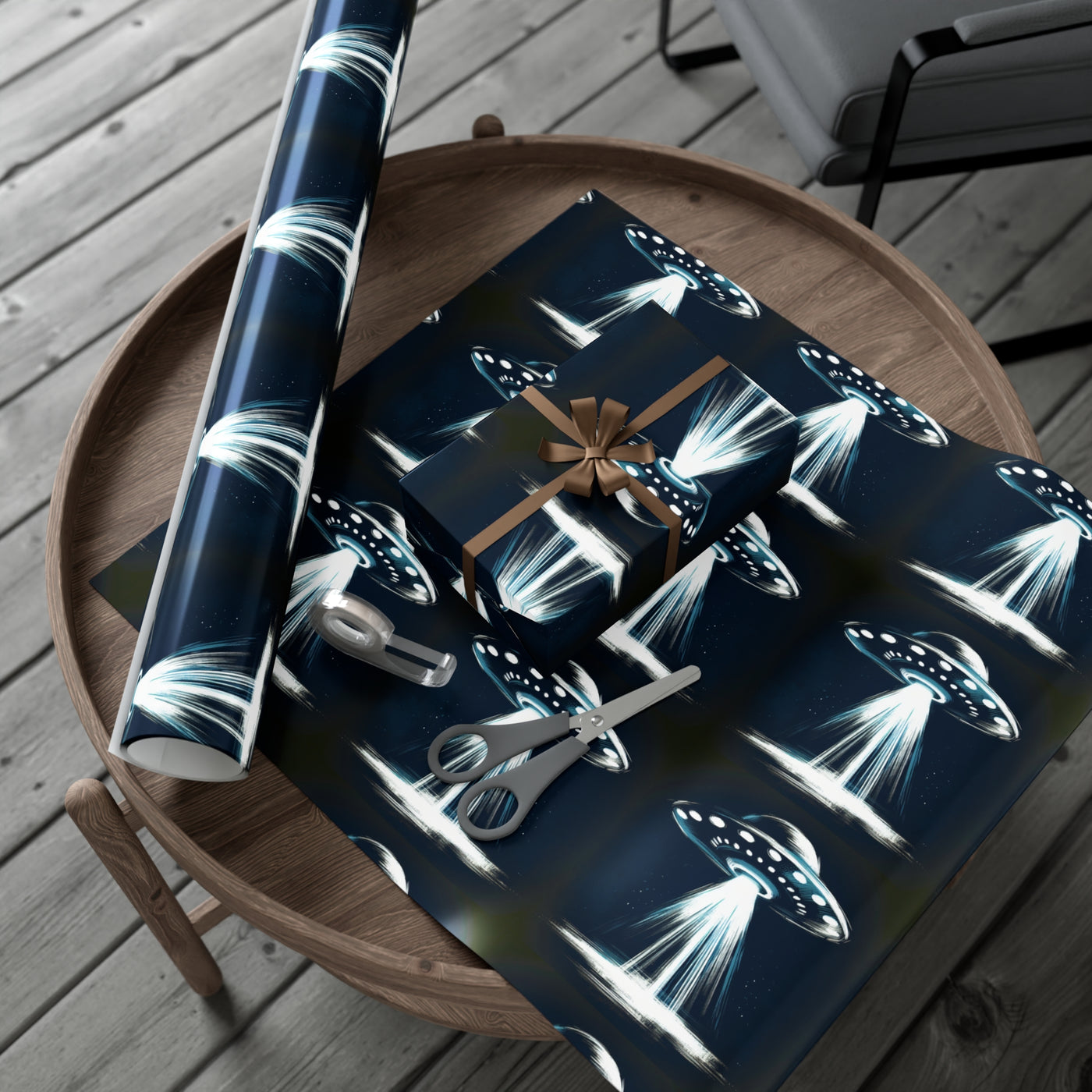 Wrapping paper with a dark blue background featuring a repeating pattern of flying saucers emitting bright beams of light.