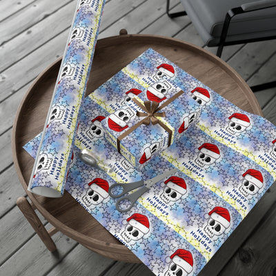 Gift wrap paper with a repeating pattern of skulls wearing Santa hats and stars.