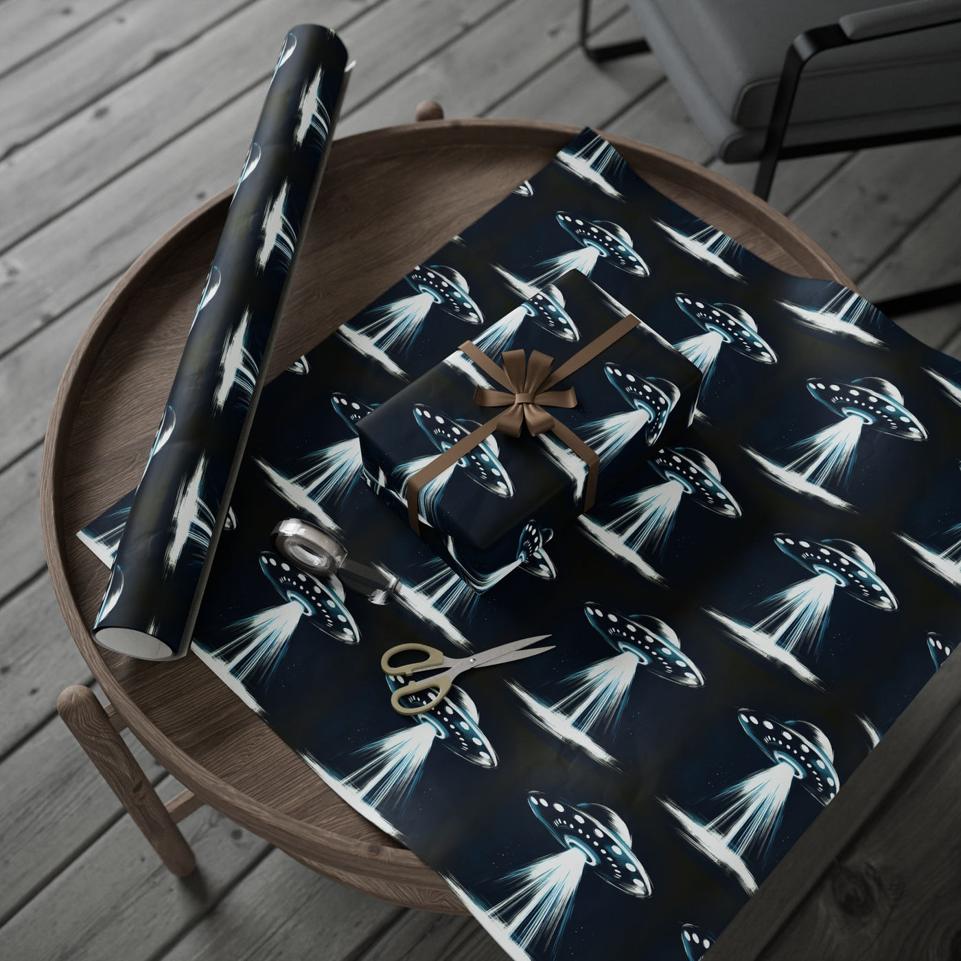 UFO-themed wrapping paper on a wooden table with scissors and a gift.
