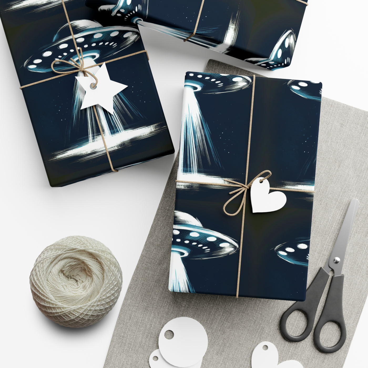 Wrapping paper with a dark blue background featuring a repeating pattern of white and blue UFOs with beams of light.