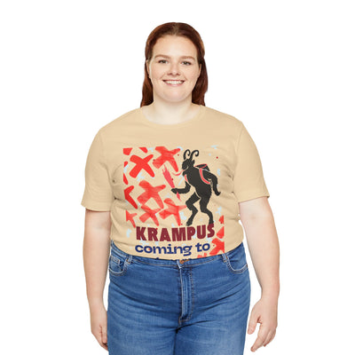 A woman wears a tan t-shirt with a Krampus graphic and text.