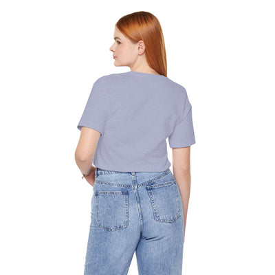 Back view of a woman wearing a light purple t-shirt and blue jeans.