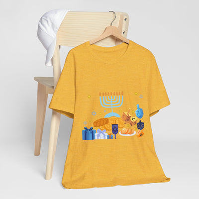 Yellow t-shirt with a Hanukkah graphic featuring a menorah, dreidels, and gifts.