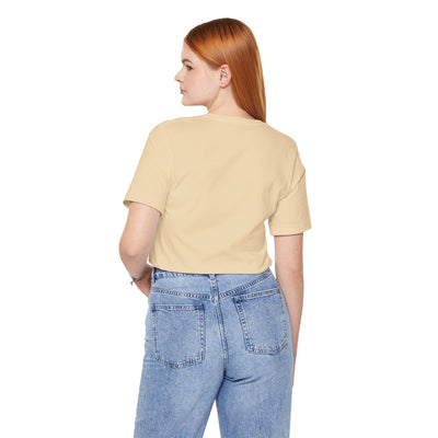 Back view of a woman wearing a light yellow t-shirt and blue jeans.
