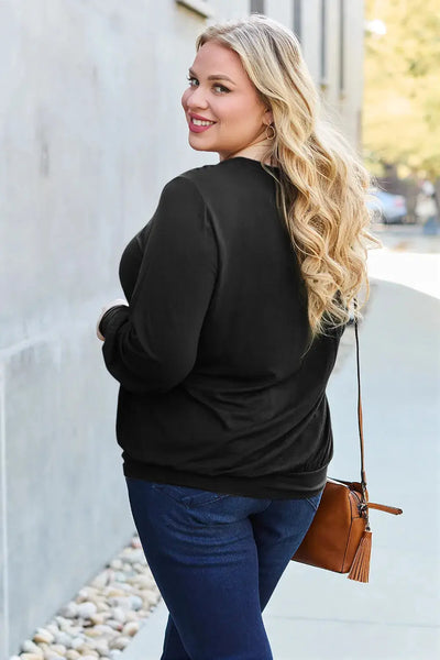 Woman in a black V-neck top and blue jeans.