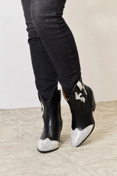 Black ankle boots with rhinestone accents and a pointed toe.