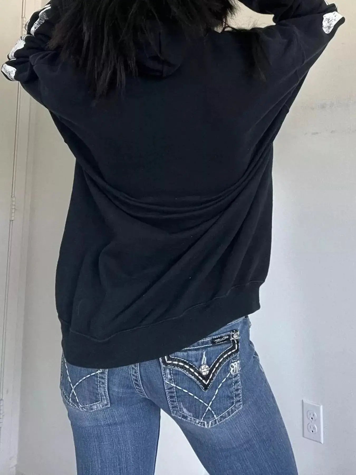 Black skeleton hoodie with drawstring and long sleeves.