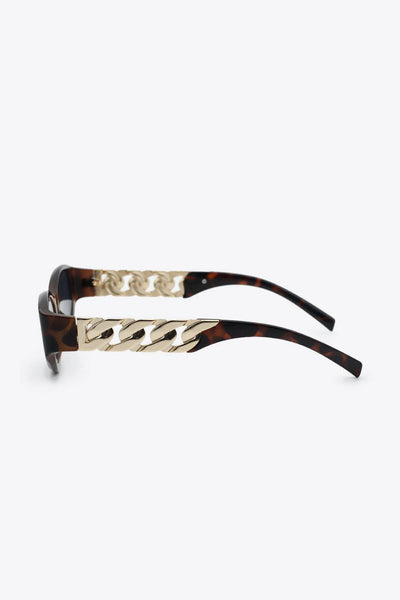 Cat eye sunglasses with tortoise shell frames and gold chain detail.