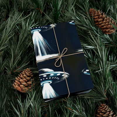 UFO design wrapping paper tied with twine, surrounded by pine needles and pinecones.