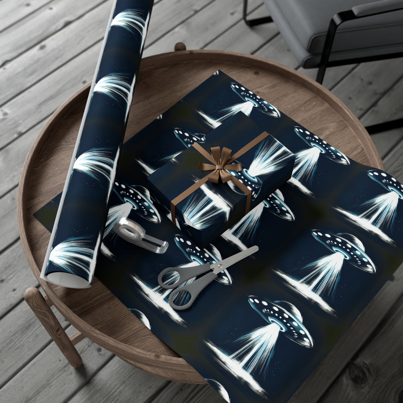 Wrapping paper with a dark blue background featuring a repeating pattern of flying saucers emitting bright beams of light.