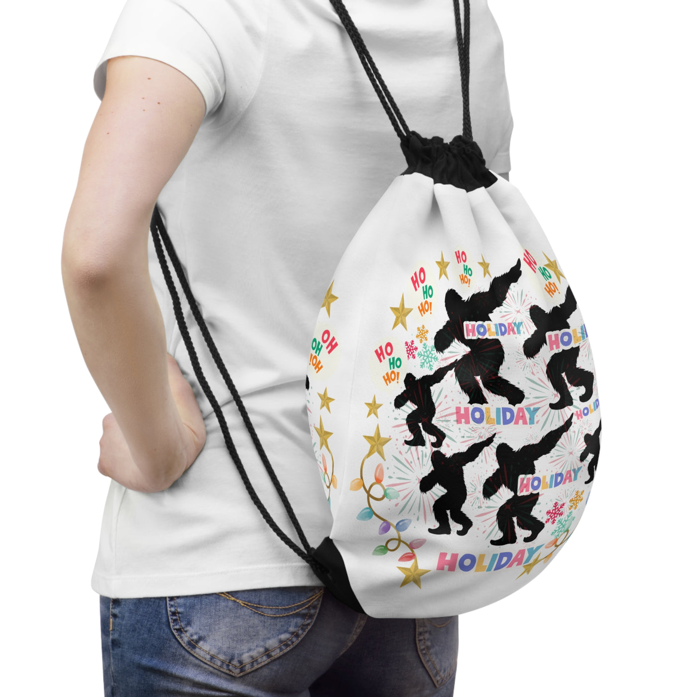 White drawstring bag with a repeating pattern of black Sasquatch silhouettes and holiday text.