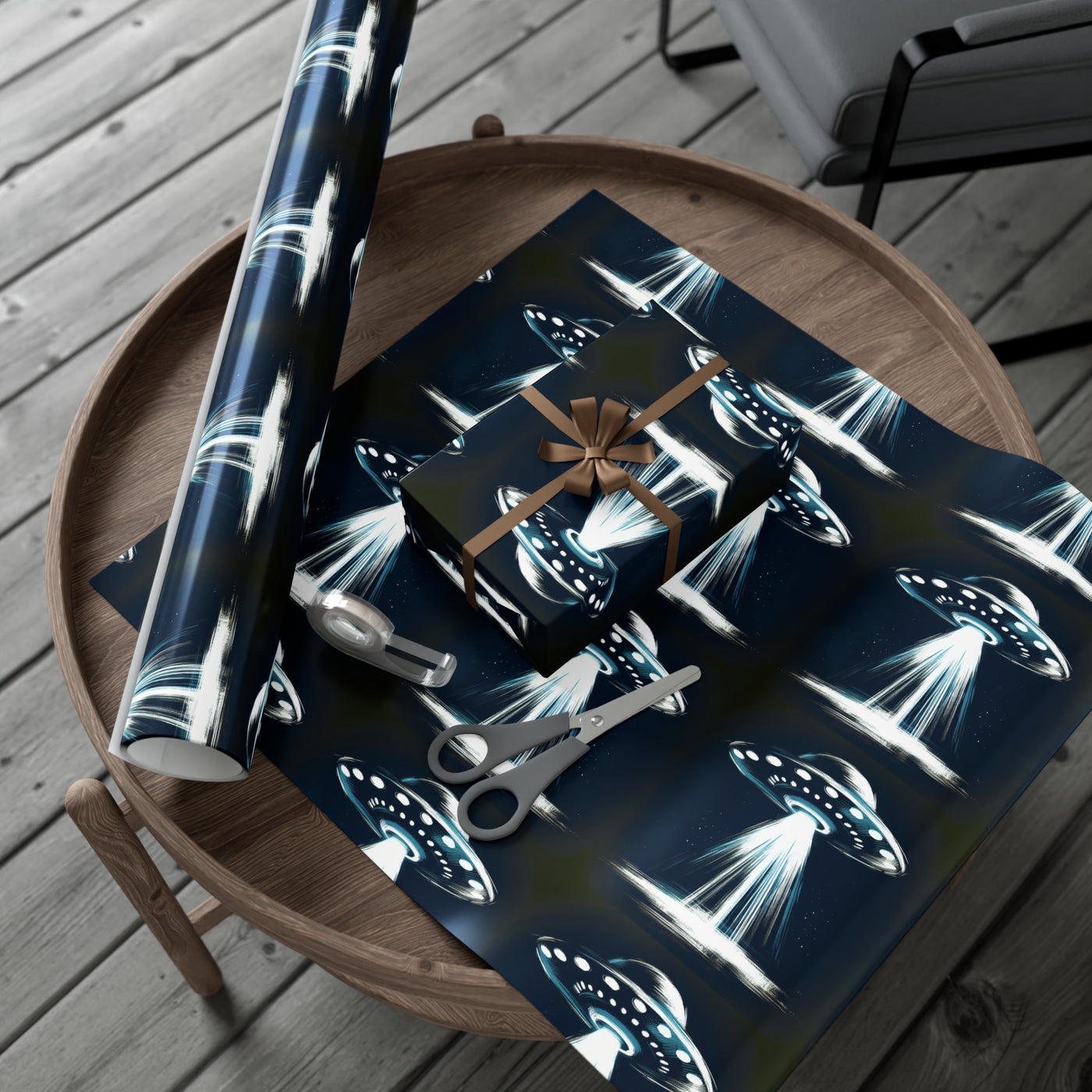 Wrapping paper with a dark blue background featuring a pattern of flying saucers emitting beams of light.