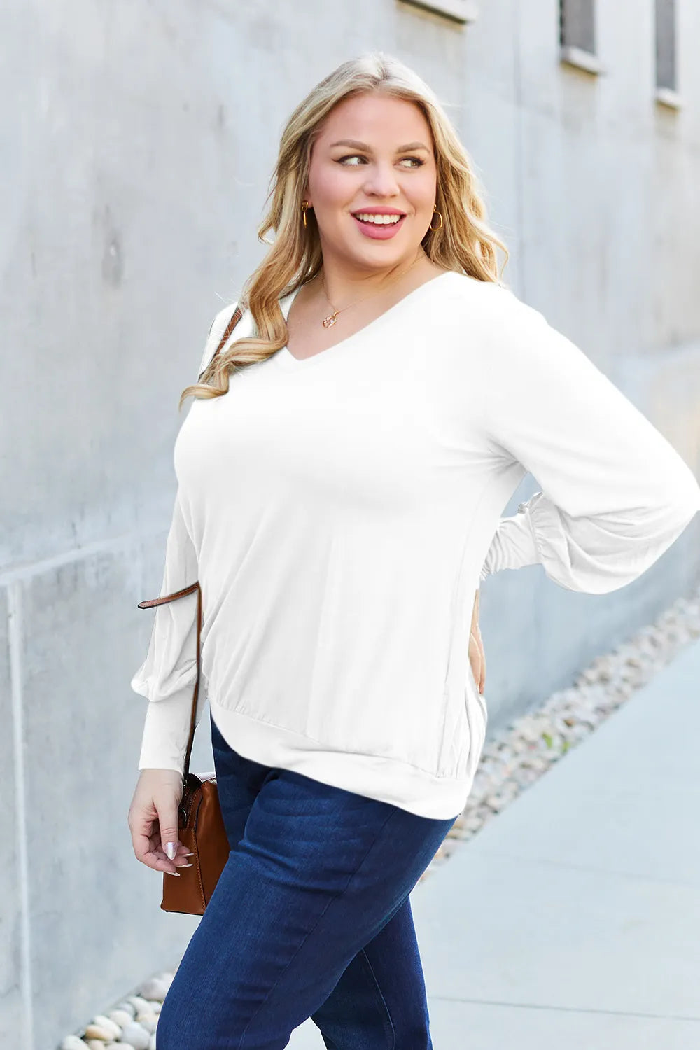 A white V-neck top with lantern sleeves and a cinched hem.