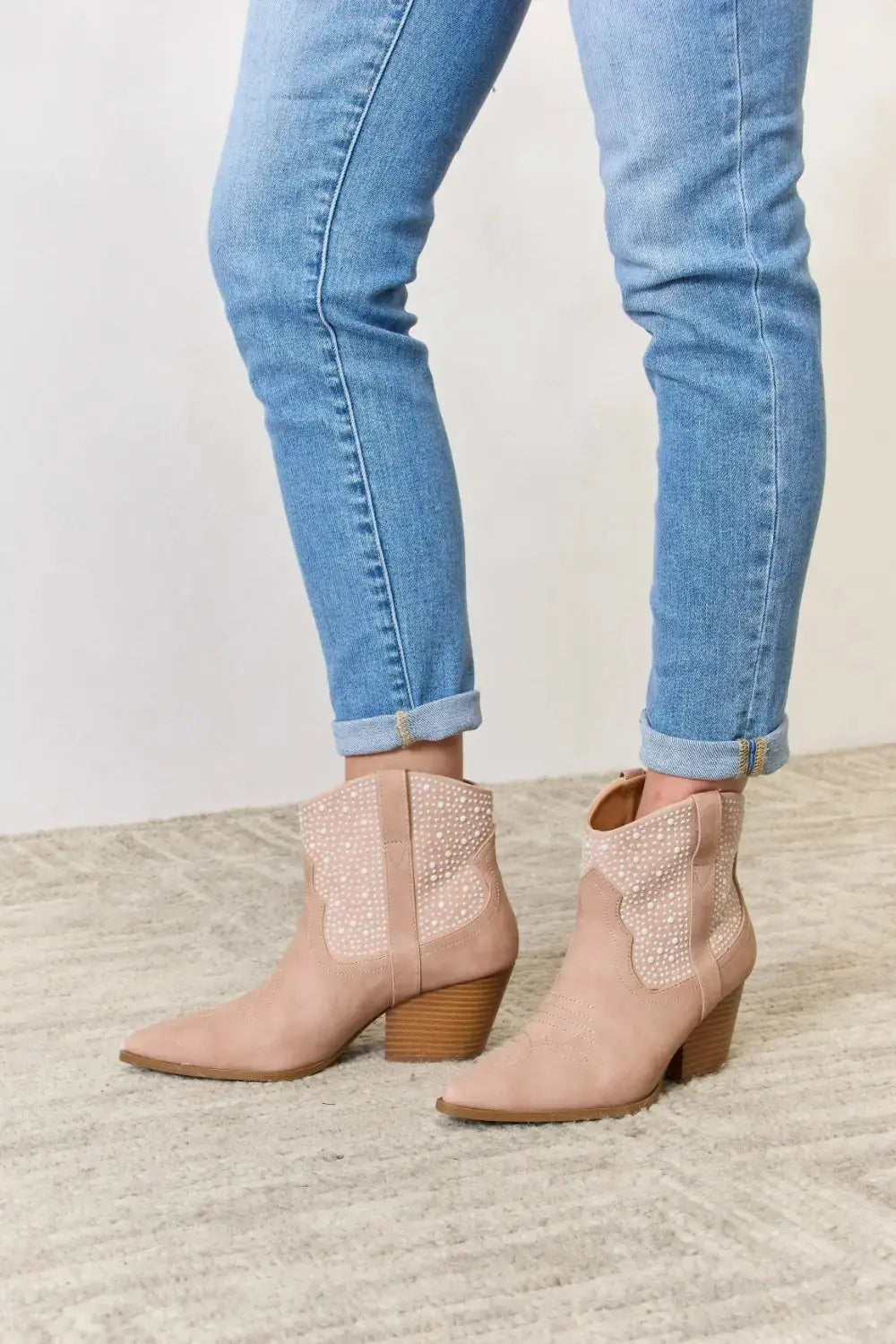 Pink rhinestone cowgirl booties with mid heels.