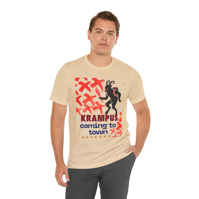 A man wears a tan t-shirt with a graphic of Krampus and the text "Krampus coming to town".