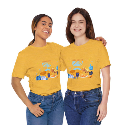Two women in yellow t-shirts with a Hanukkah graphic stand with arms around each other.