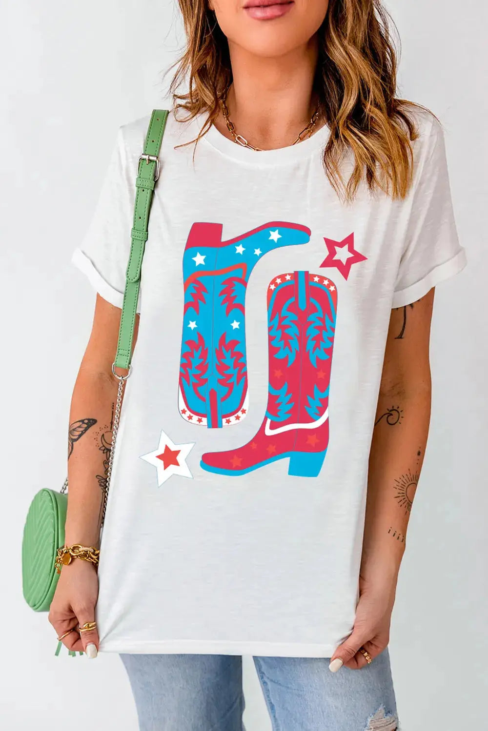 White t-shirt with a graphic of red, white, and blue cowboy boots and stars.