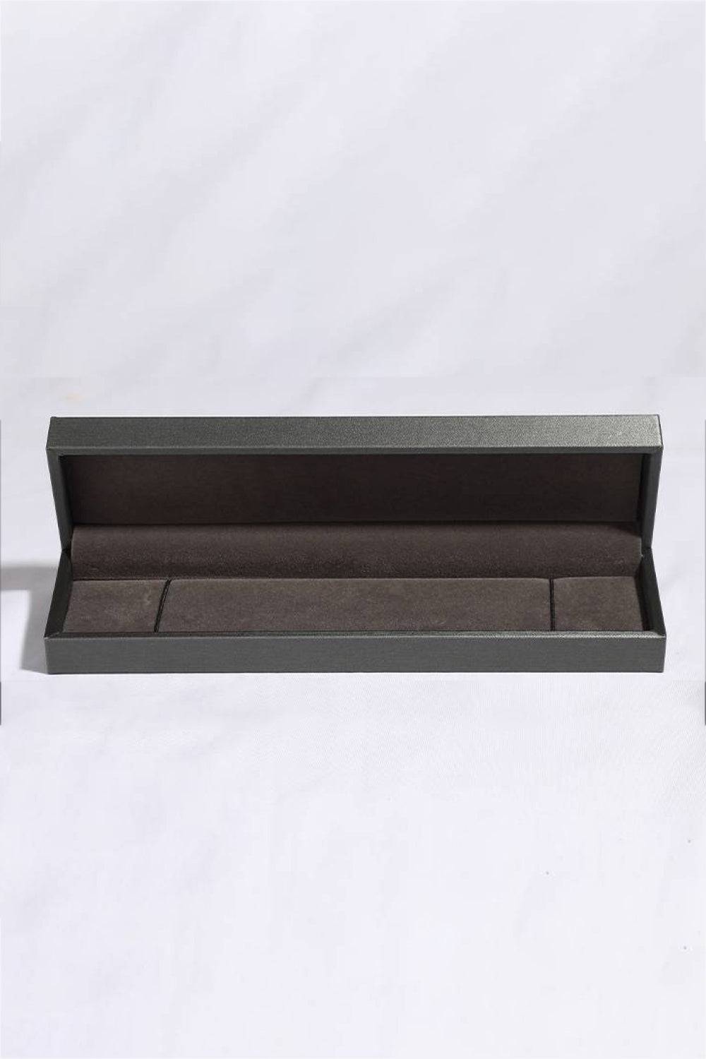 A dark gray, open jewelry box with a brown velvet interior.