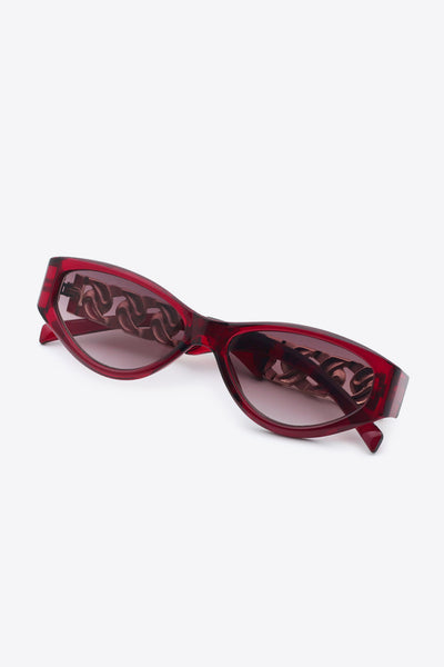 Red cat-eye sunglasses with chain detail on the temples.