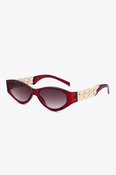 Red cat-eye sunglasses with gold chain detail on the temples.