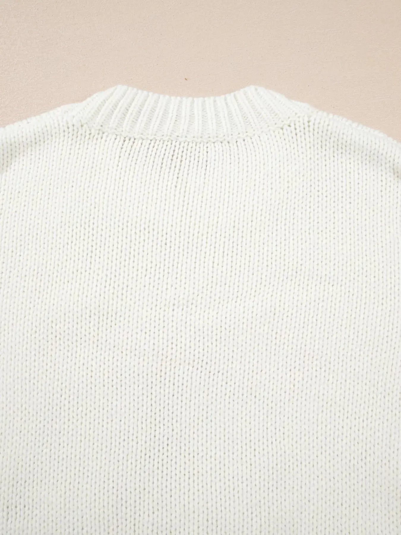 White knit sweater with a ribbed neckline.