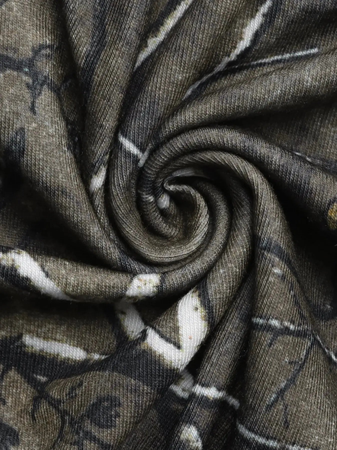 Asymmetrical long sleeve top with a camouflage print and cutout detail.