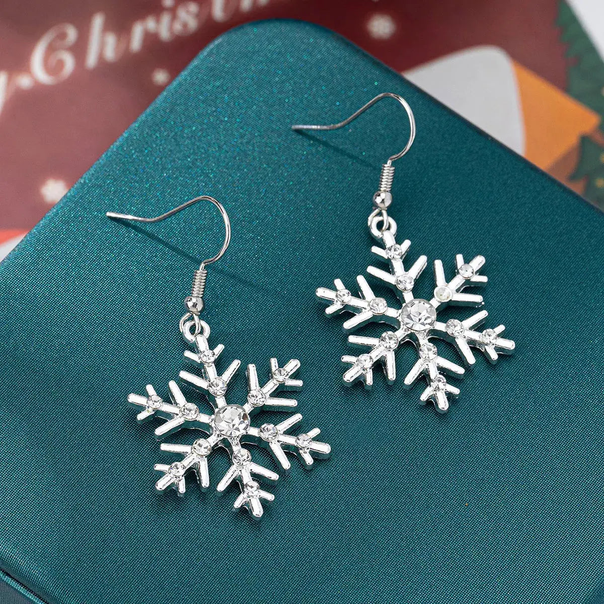 Silver-plated snowflake dangle earrings with rhinestones.