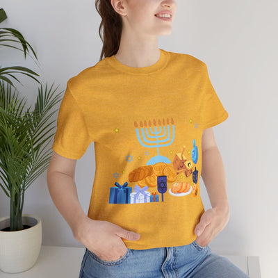 Yellow t-shirt with a graphic of Hanukkah symbols including a menorah, dreidels, and gifts.