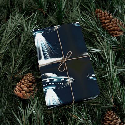 Wrapping paper with a dark blue background featuring a repeating pattern of white and blue UFOs with beams of light, tied with twine.