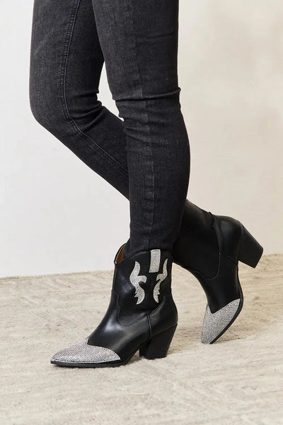 Black ankle boots with rhinestone accents and a pointed toe.