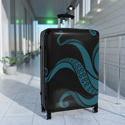 Large teal tentacle suitcase with swivel wheels in modern hallway, perfect for ocean-themed travel accessories.