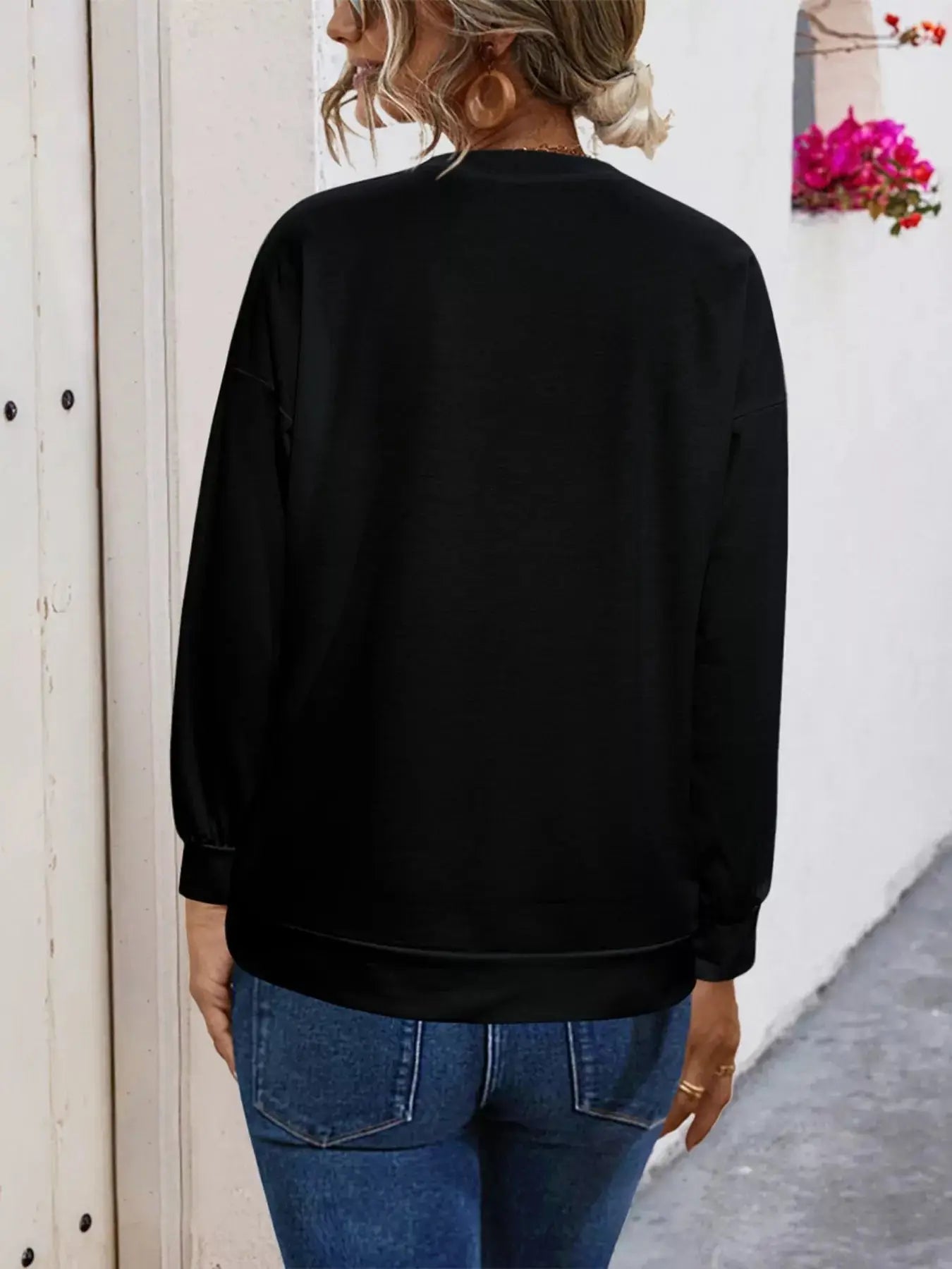 Black round neck t-shirt with long sleeves and a comfortable fit.