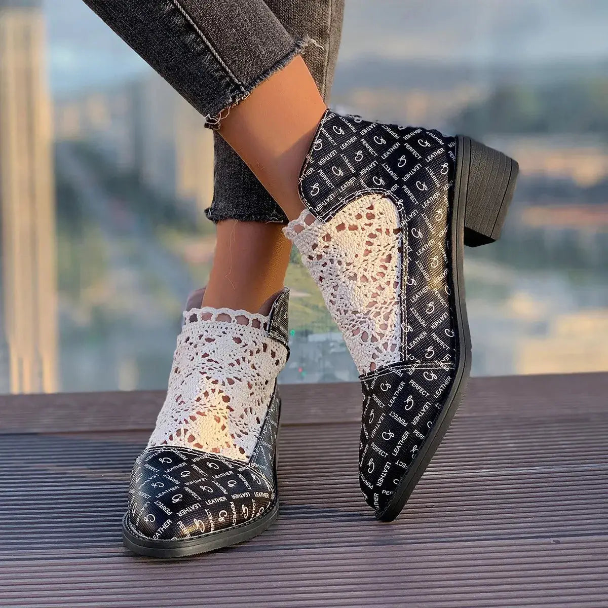 Black and white printed low heel boots with white lace accents.