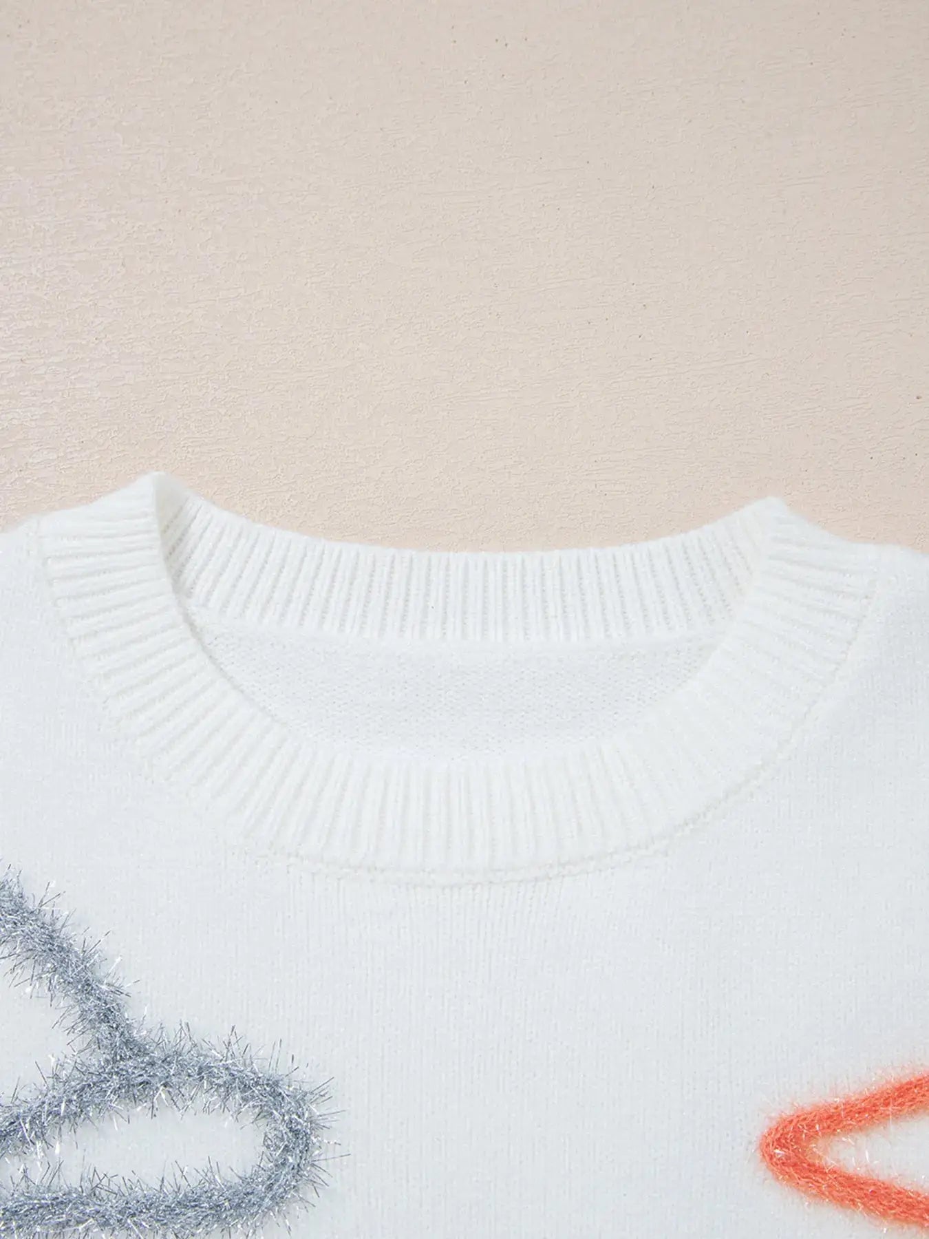 White knit sweater with a crew neck and sparkly embellishments.
