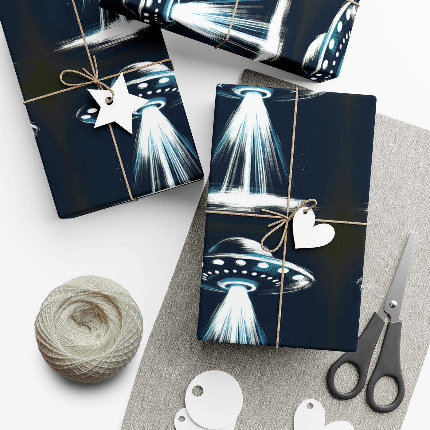 Wrapping paper with a dark blue background featuring a repeating pattern of white and blue UFOs with beams of light.
