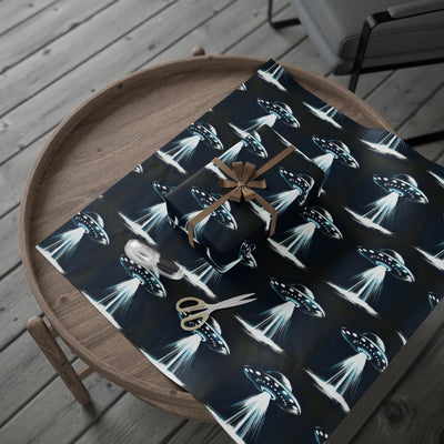 UFO-themed wrapping paper with a gift, ribbon, and scissors on a wooden table.