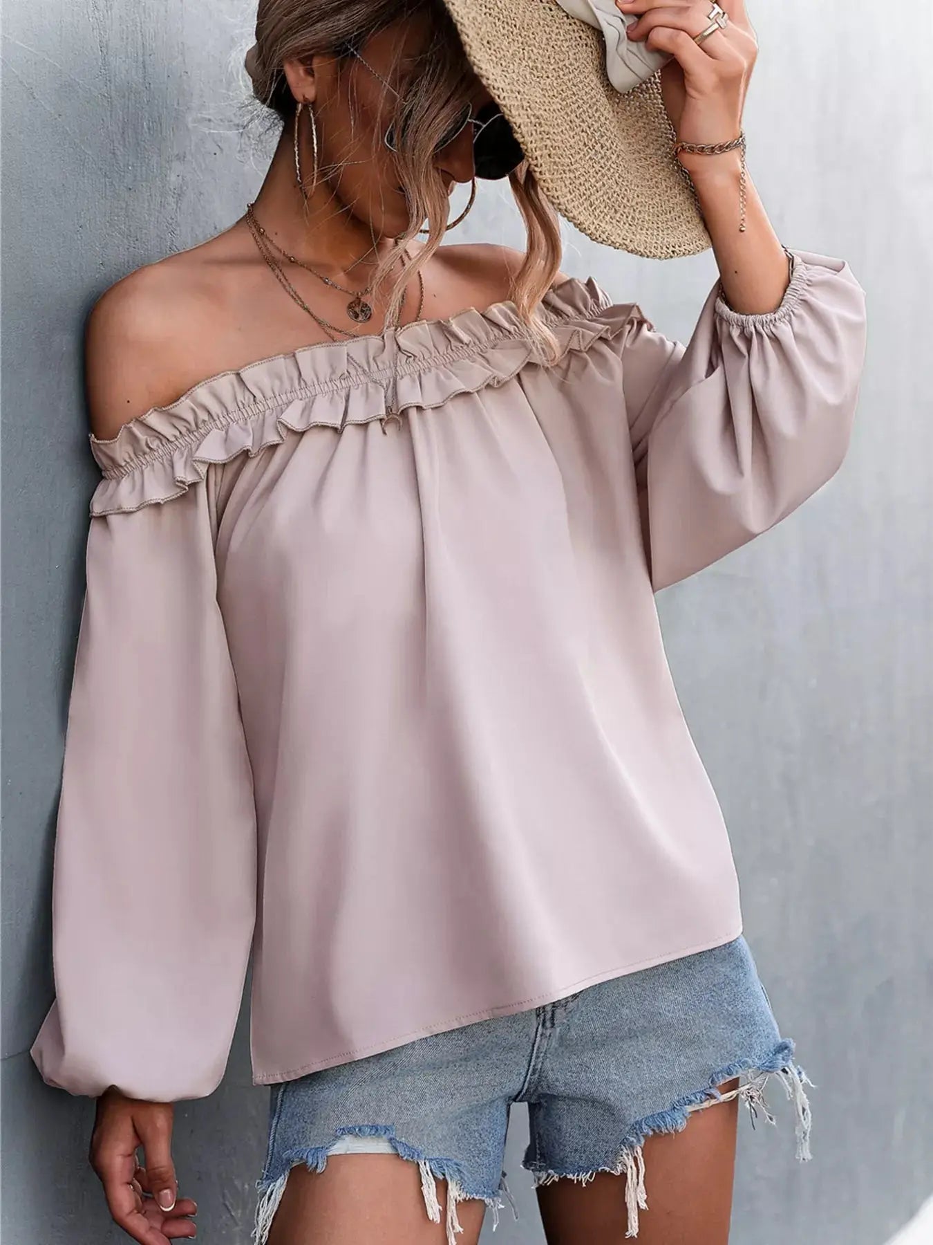 Off-shoulder ruffled long sleeve blouse in a light pink polyester blend.