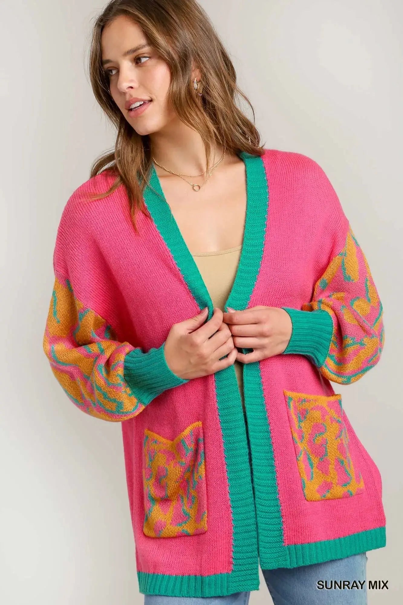 Pink open-front cardigan with green trim and animal print sleeves and pockets.