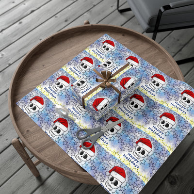 Gift wrap paper with a blue background, white stars, skulls wearing Santa hats, and "Happy Holidays" text.