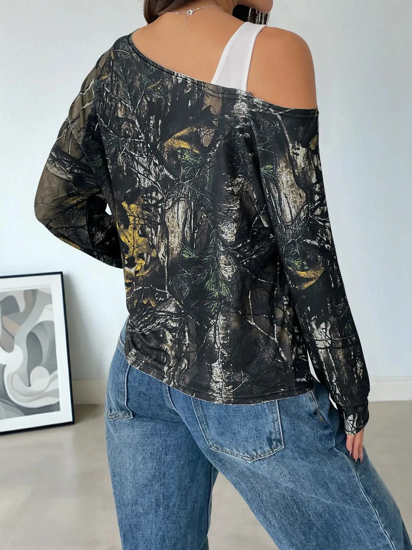 Asymmetrical long sleeve top with a camouflage print and cutout detail.