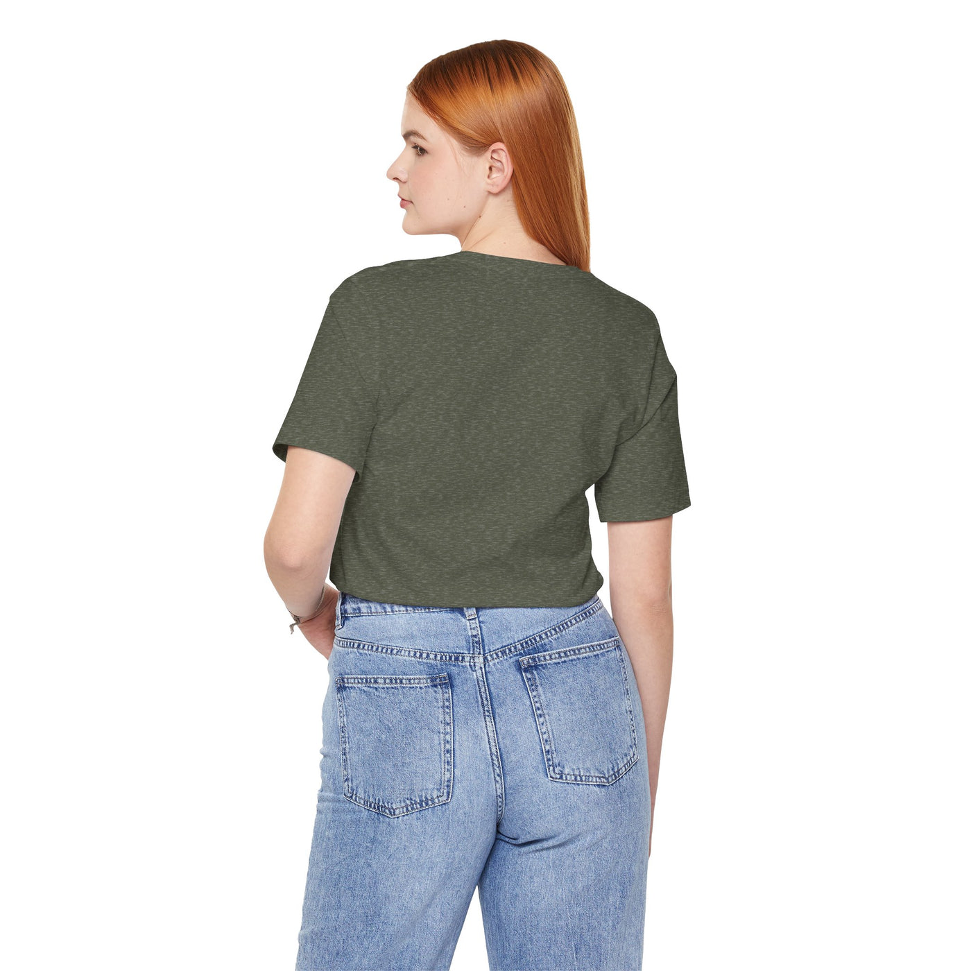 A woman wearing a dark green t-shirt and light blue jeans.