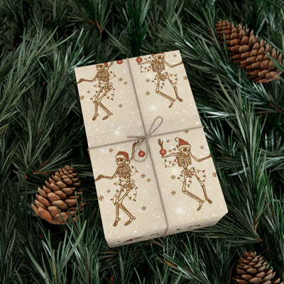 Gift wrap with a repeating pattern of skeletons wearing Santa hats and holding ornaments, surrounded by snowflakes and lights.
