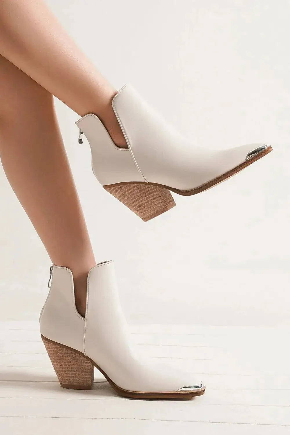 White PU leather ankle boots with pointed metal-tip toe and block heel.