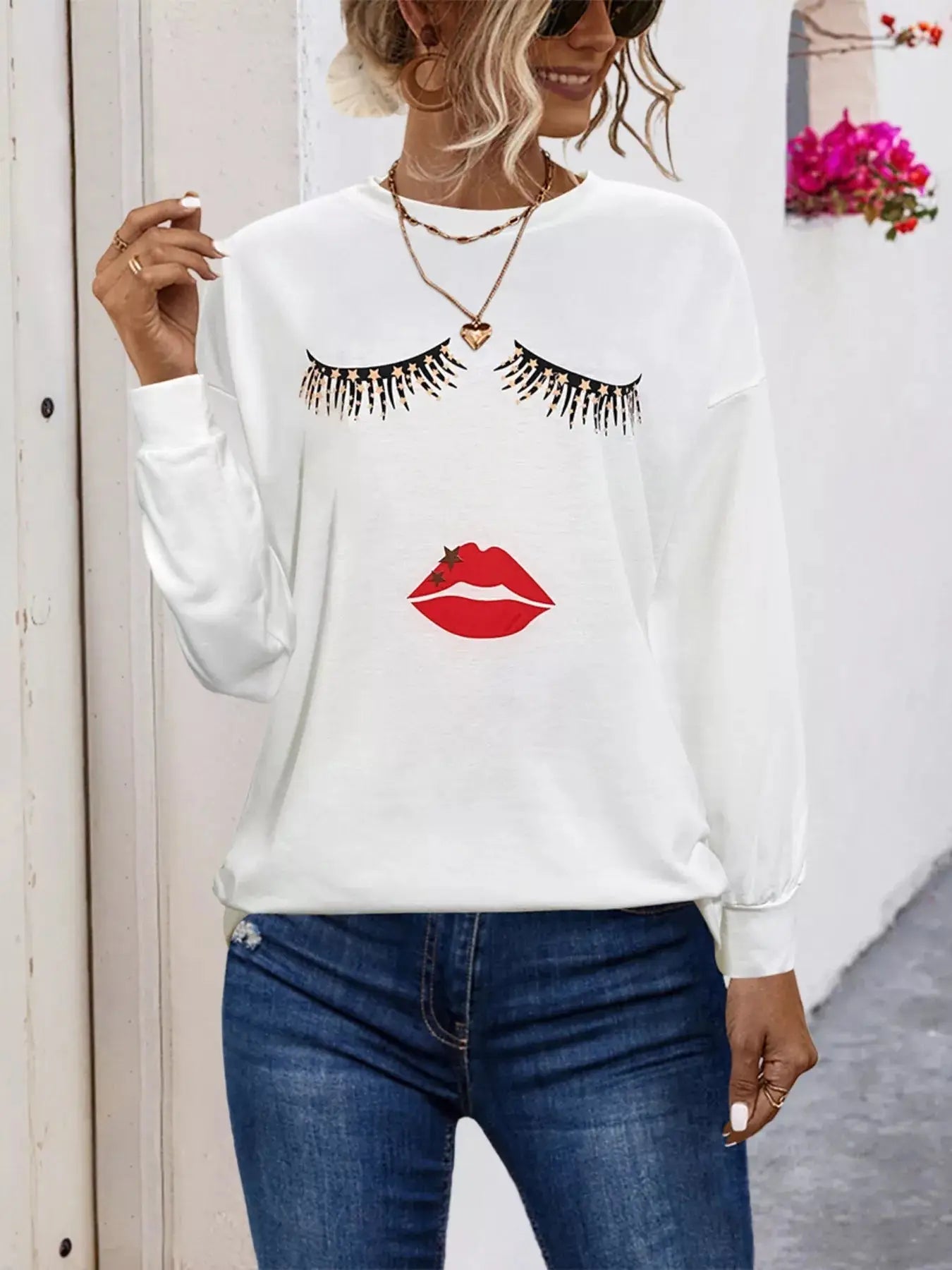 White graphic t-shirt with eyelashes and lips print.
