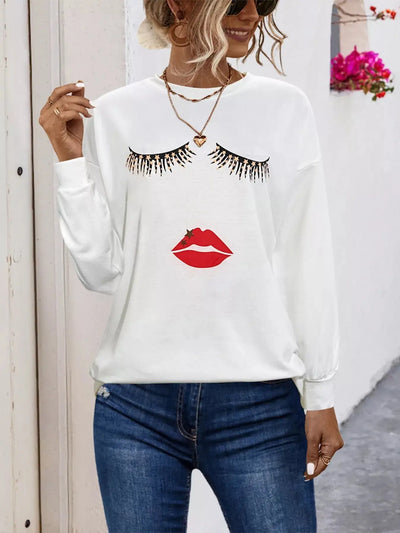 White graphic t-shirt with eyelashes and lips print.