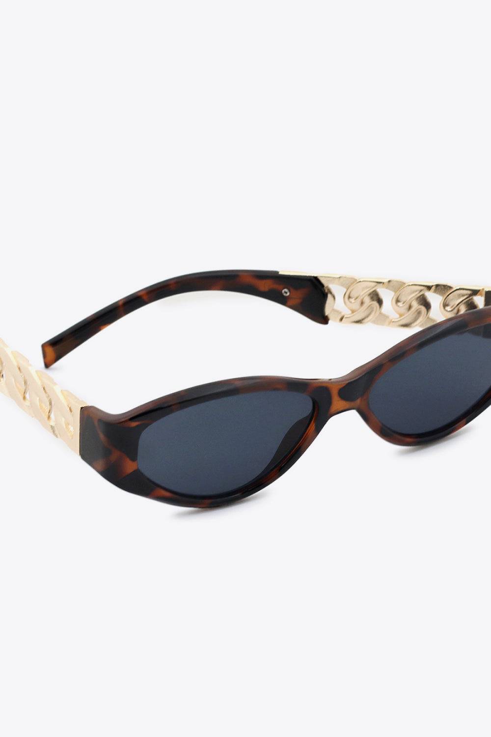 Cat eye sunglasses with tortoise shell frames and gold chain detail.
